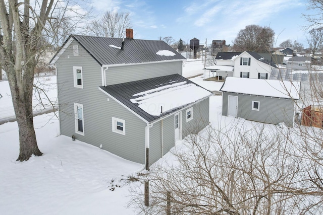 32 Railroad St, Jeffersonville, OH 43128 - snow covered back of property featuring a chimney and metal roof