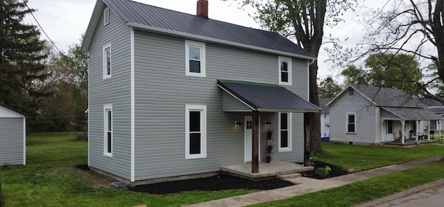 32 Railroad St, Jeffersonville, OH 43128 - view of front of house with a chimney, a front yard, and metal roof