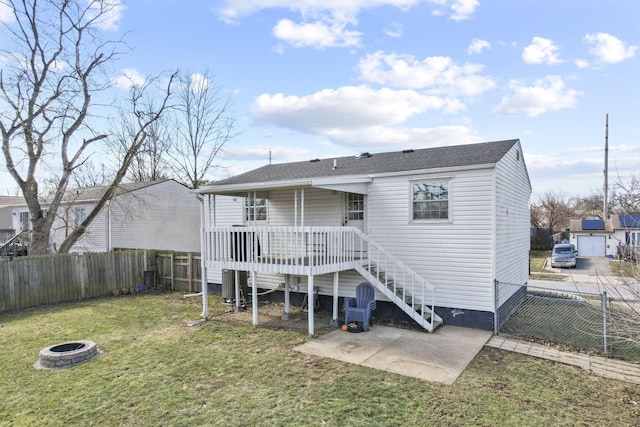 rear view of house with an outdoor fire pit, a lawn, a fenced backyard, and stairway