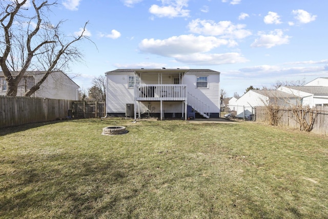 back of house featuring a fire pit, a fenced backyard, stairway, and a lawn