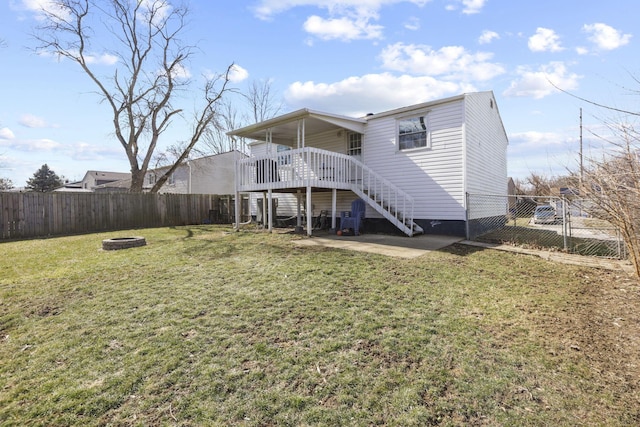 rear view of property with stairs, a lawn, and a fenced backyard