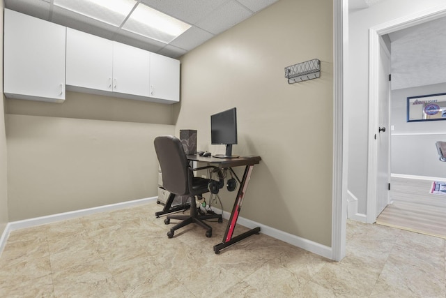 home office with a drop ceiling and baseboards