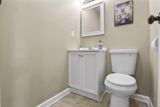 bathroom with vanity, toilet, and baseboards