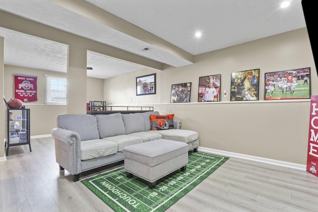 living room with recessed lighting, wood finished floors, visible vents, baseboards, and beamed ceiling