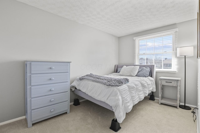 bedroom with light carpet, a textured ceiling, and baseboards