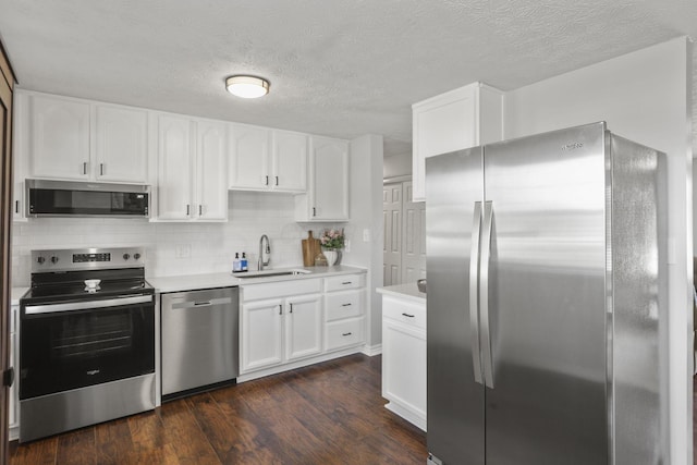 kitchen with dark wood-type flooring, a sink, stainless steel appliances, light countertops, and backsplash