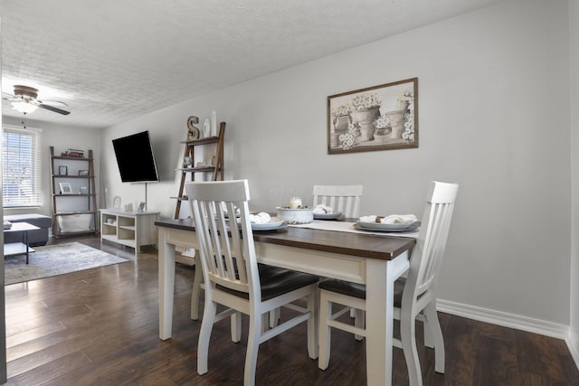 dining area featuring ceiling fan, baseboards, dark wood finished floors, and a textured ceiling