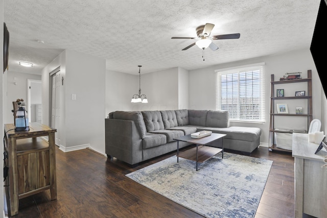 living room featuring dark wood finished floors, a textured ceiling, and ceiling fan with notable chandelier