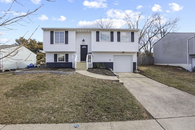 split foyer home with an attached garage, driveway, a front lawn, and fence