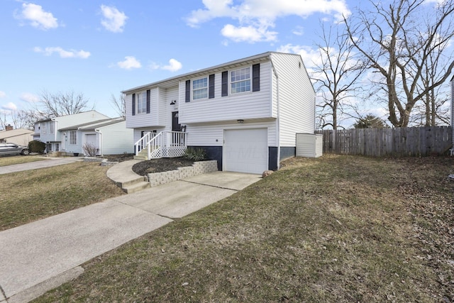 split foyer home featuring fence, driveway, and an attached garage