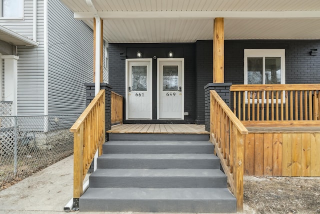 entrance to property featuring brick siding and a porch