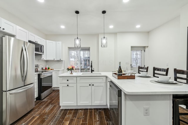 kitchen featuring beverage cooler, stainless steel appliances, a sink, white cabinets, and dark wood-style floors