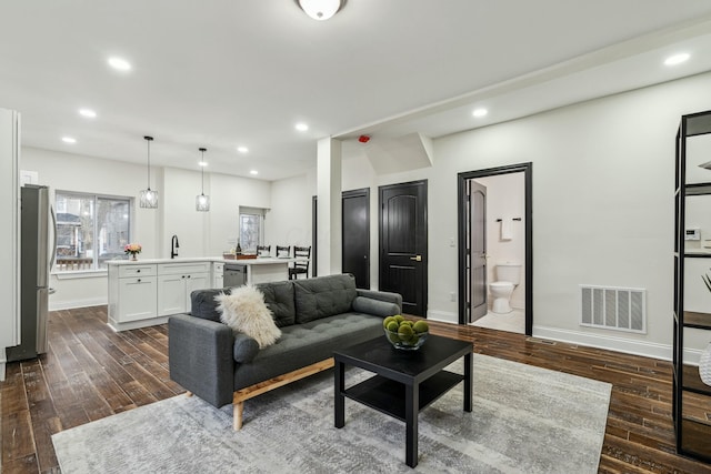 living room featuring dark wood-style floors, baseboards, visible vents, and recessed lighting