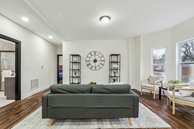 living room with baseboards, visible vents, wood finished floors, and recessed lighting