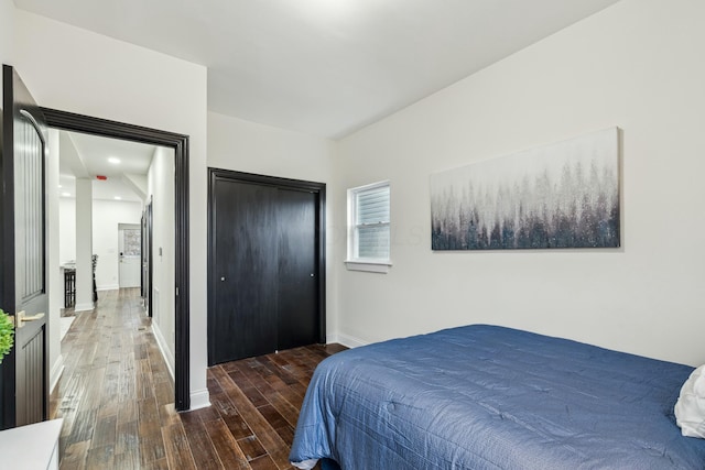 bedroom featuring a closet, baseboards, and wood finished floors