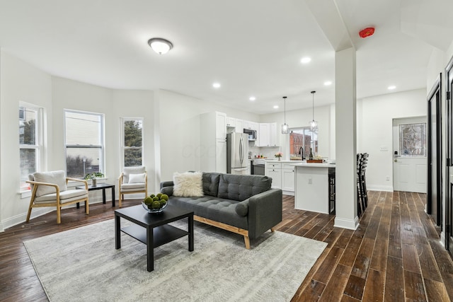 living area with plenty of natural light, dark wood-type flooring, and recessed lighting