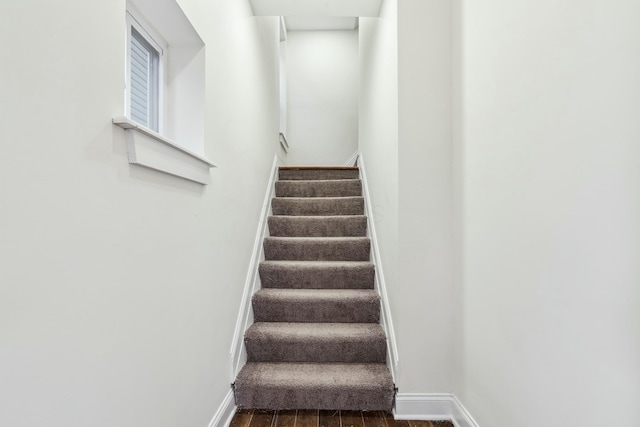 stairway featuring baseboards and wood finished floors