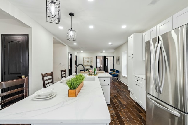 kitchen featuring dark wood-style floors, a large island, recessed lighting, freestanding refrigerator, and a sink