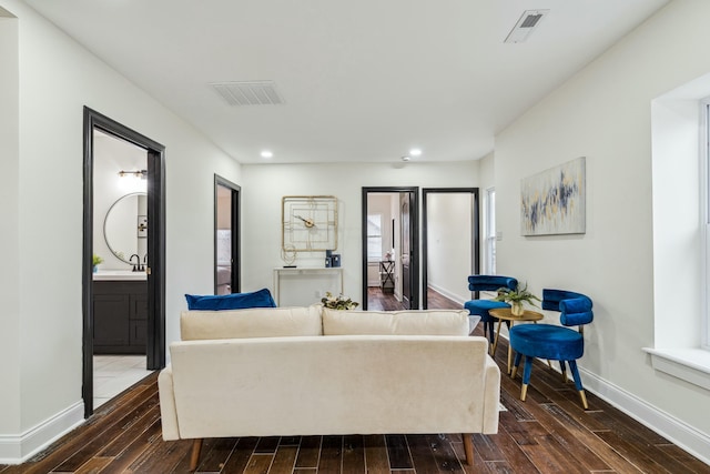 living room with visible vents, dark wood finished floors, and baseboards