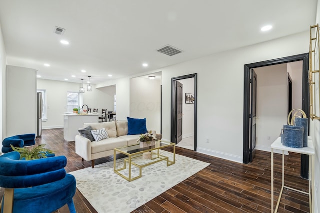 living area with dark wood-style flooring, visible vents, and recessed lighting