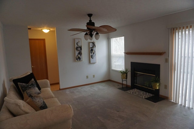 unfurnished living room with carpet floors, a fireplace with flush hearth, a ceiling fan, and baseboards