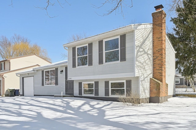 split level home with a garage and a chimney