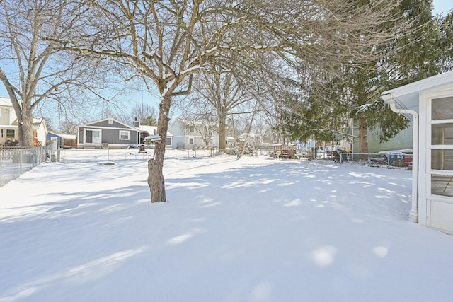 snowy yard with fence and a residential view