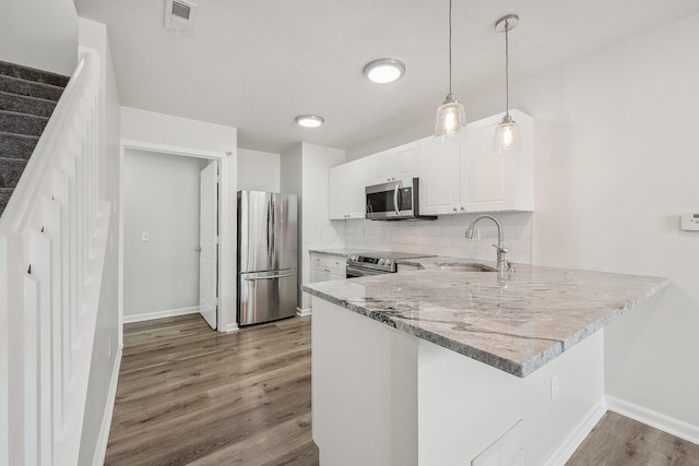 kitchen featuring stainless steel appliances, visible vents, backsplash, a sink, and light stone countertops