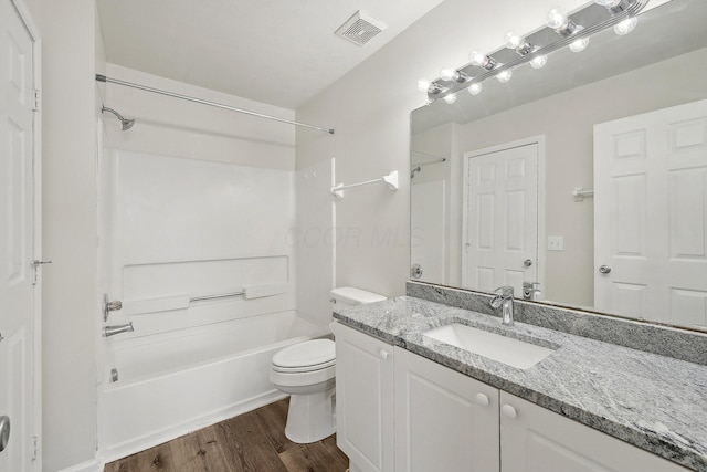 bathroom with visible vents, toilet, tub / shower combination, vanity, and wood finished floors