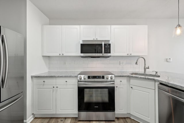 kitchen featuring appliances with stainless steel finishes, a sink, and white cabinetry