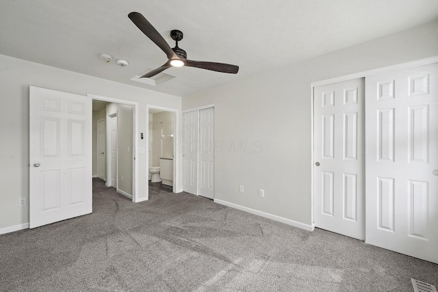 unfurnished bedroom with baseboards, carpet, visible vents, and multiple closets