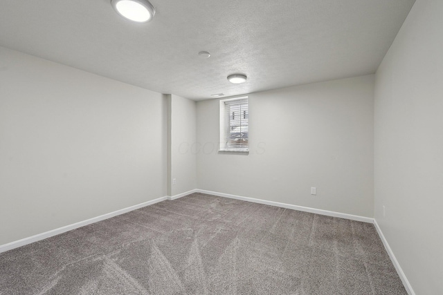 carpeted spare room with baseboards and a textured ceiling