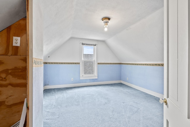 bonus room with vaulted ceiling, a textured ceiling, carpet, and baseboards