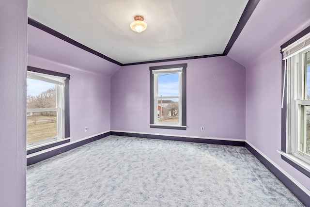 additional living space featuring baseboards, vaulted ceiling, and carpet flooring