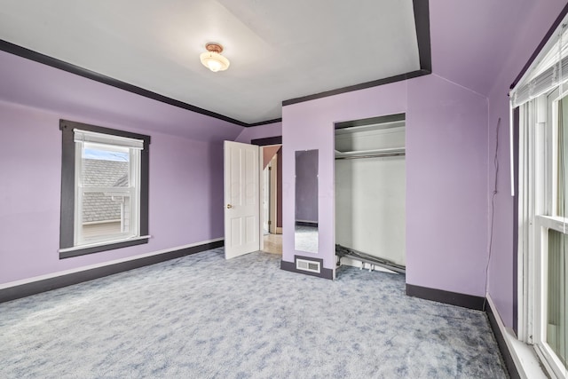 unfurnished bedroom featuring carpet floors, a closet, visible vents, ornamental molding, and baseboards