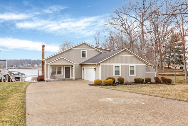 view of front of house featuring a chimney, a front lawn, and concrete driveway