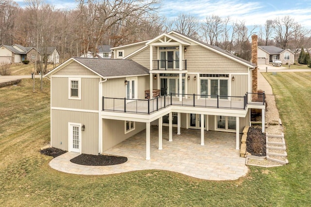 rear view of house featuring a balcony, a patio area, stairway, and a yard