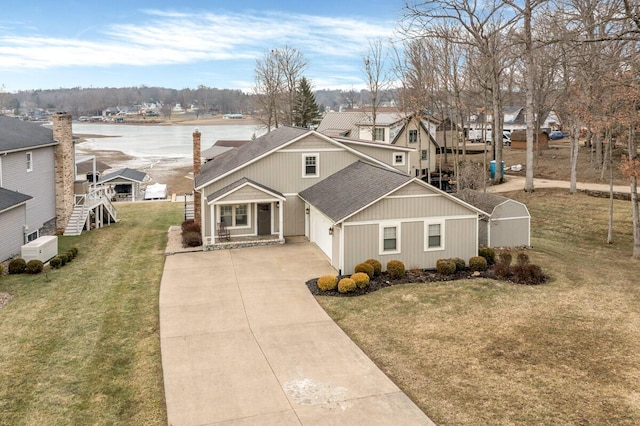 view of front of home with a shingled roof, concrete driveway, and a front yard