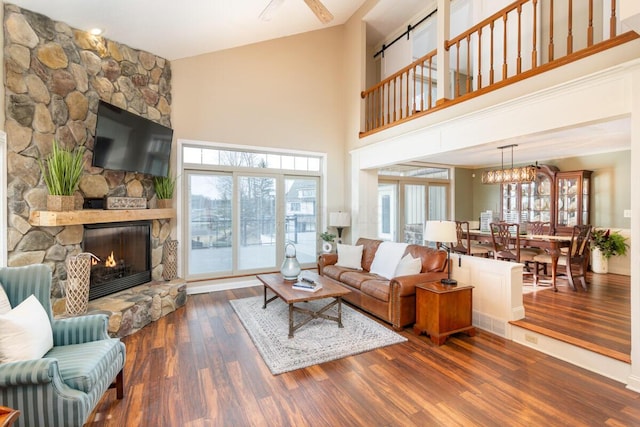 living room featuring a stone fireplace and wood finished floors