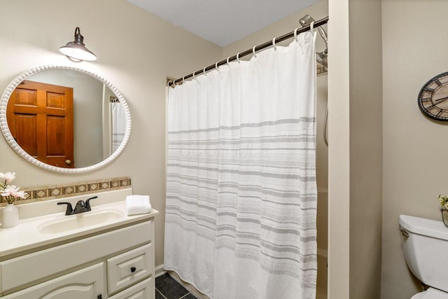 bathroom featuring curtained shower, vanity, and toilet