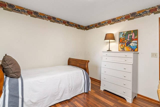 bedroom featuring wood finished floors and baseboards