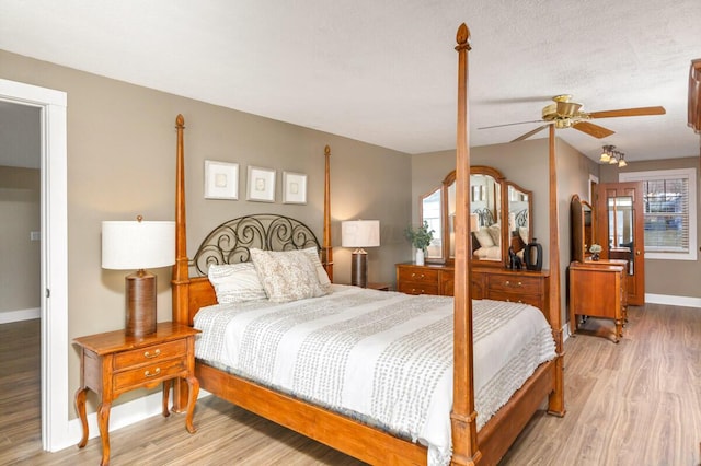 bedroom with light wood finished floors, ceiling fan, multiple windows, and baseboards