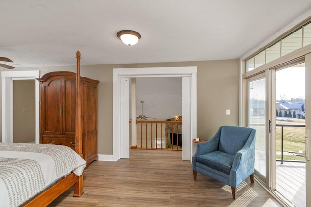 bedroom with access to outside, baseboards, multiple windows, and light wood finished floors