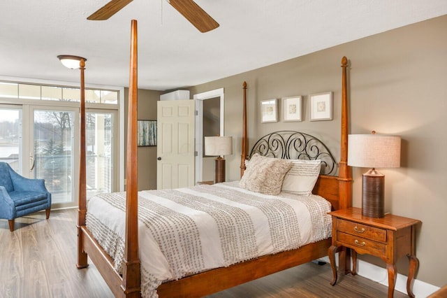 bedroom featuring access to outside, wood finished floors, and a ceiling fan