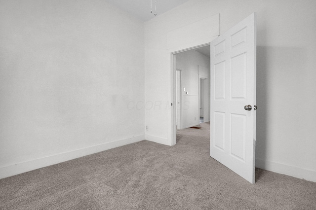 empty room featuring carpet flooring and baseboards