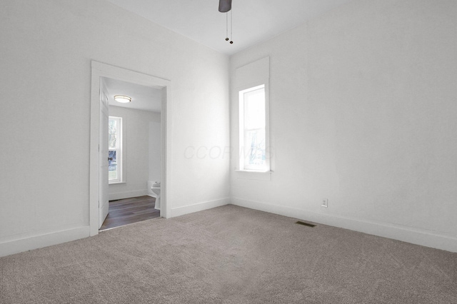 empty room with a ceiling fan, baseboards, visible vents, and carpet flooring