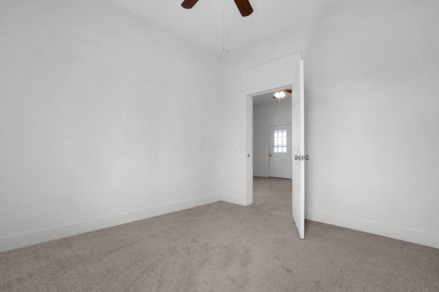 unfurnished room featuring light carpet, vaulted ceiling, a ceiling fan, and baseboards