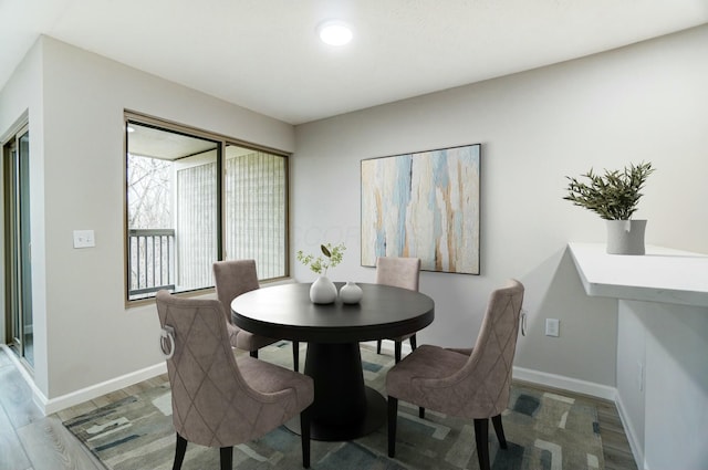 dining space with light wood-type flooring and baseboards