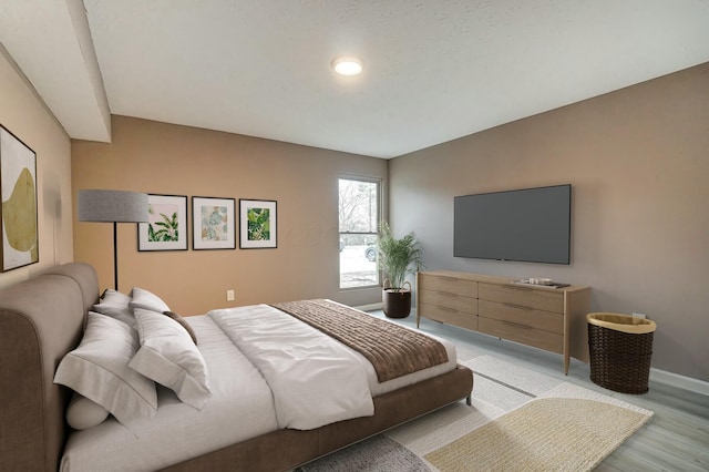 bedroom with light wood-style flooring and baseboards