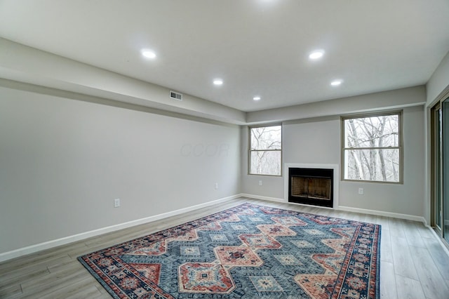 unfurnished living room with recessed lighting, visible vents, light wood-style flooring, and a fireplace